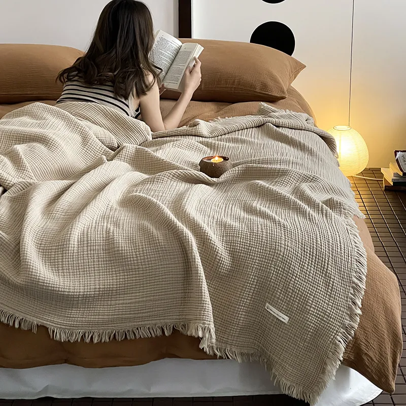 150 by 200 cm cotton throw spread across a bed