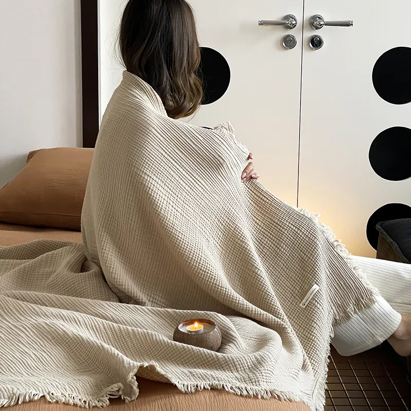 Adult wrapped in the cream throw, seen from behind; no face shown