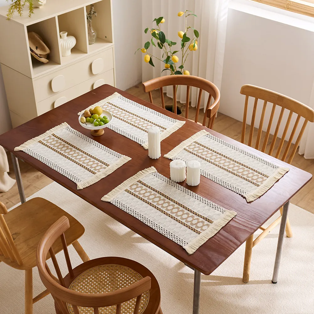 Four off-white and beige woven placemats arranged on a wood dining table